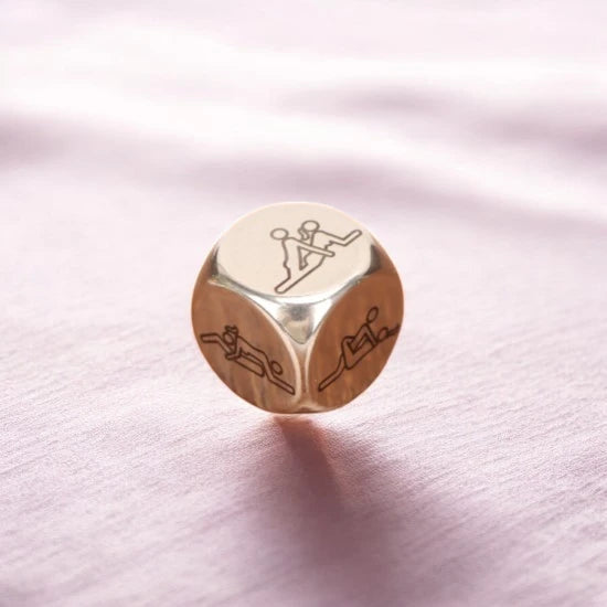 A metallic dice with sexual positions on 6 sides.