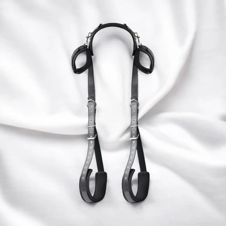 A pair of black bondage restraining straps with adjustable buckles and padding.